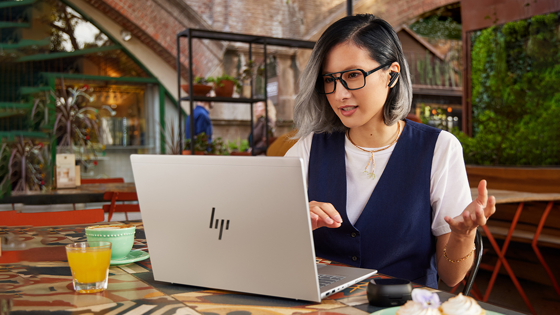 Nainen istuu kannettavan tietokoneen ääressä.