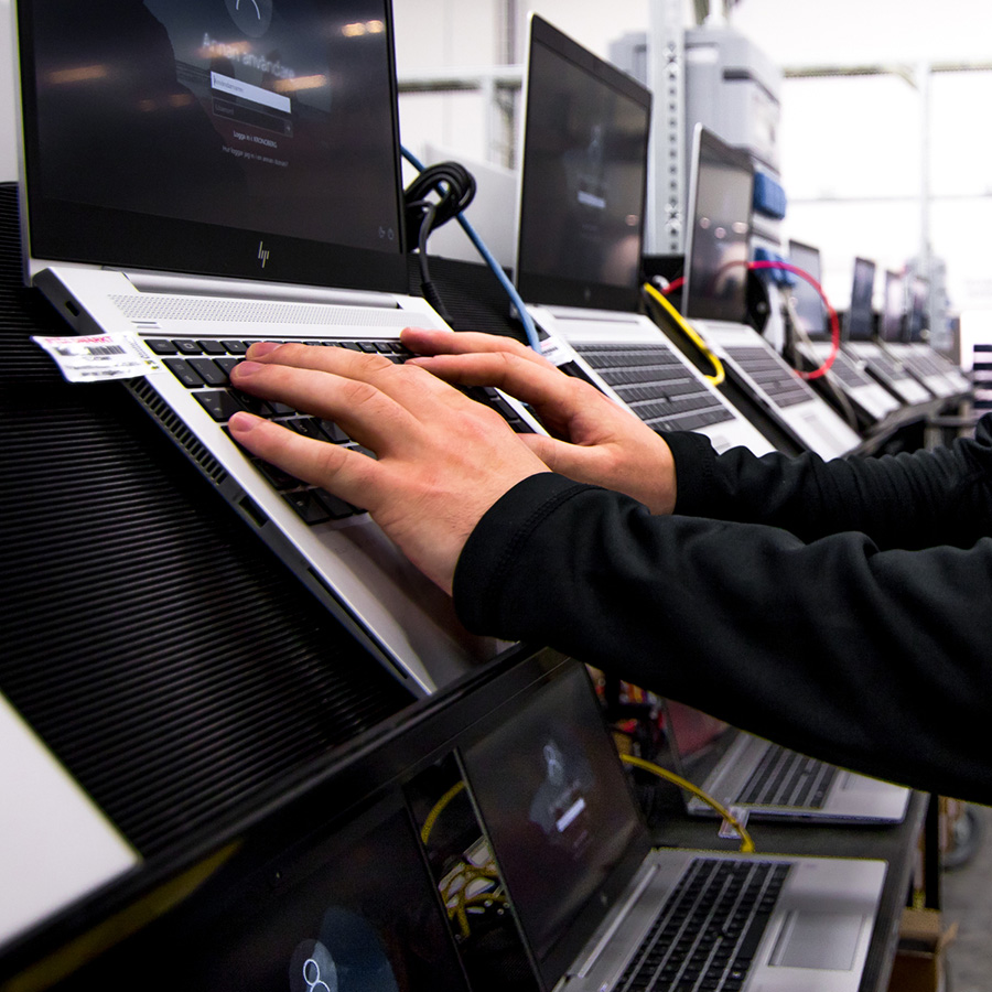 Atean logistiikkakeskuksen työntekijä kunnostaa kannettavia tietokoneita uudelleenkäyttöä varten. 