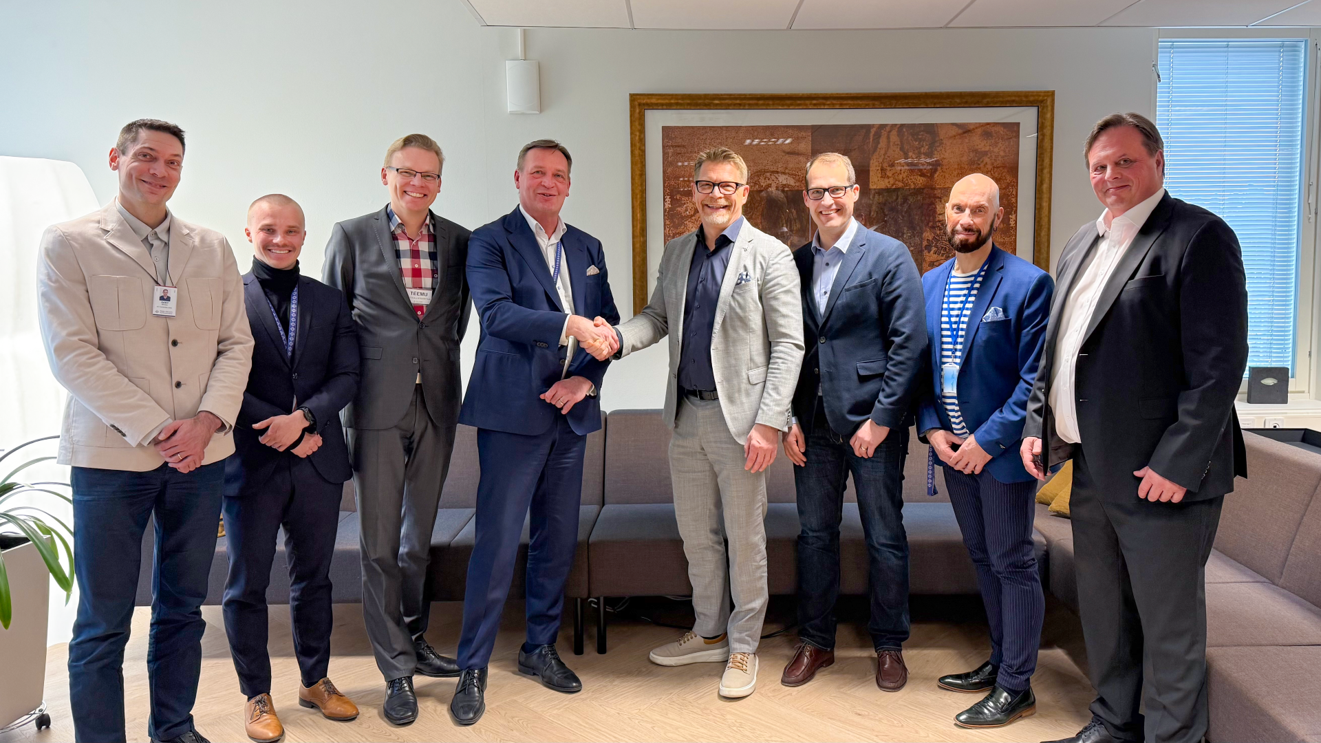 Päijät-Hämeen hyvinvointialueen tietohallintojohtaja Teemu Mäkelä kättelee Atean toimitusjohtaja Juha Sihvosta. Heidän vierellään seisoo kummankin organisaation edustajia.